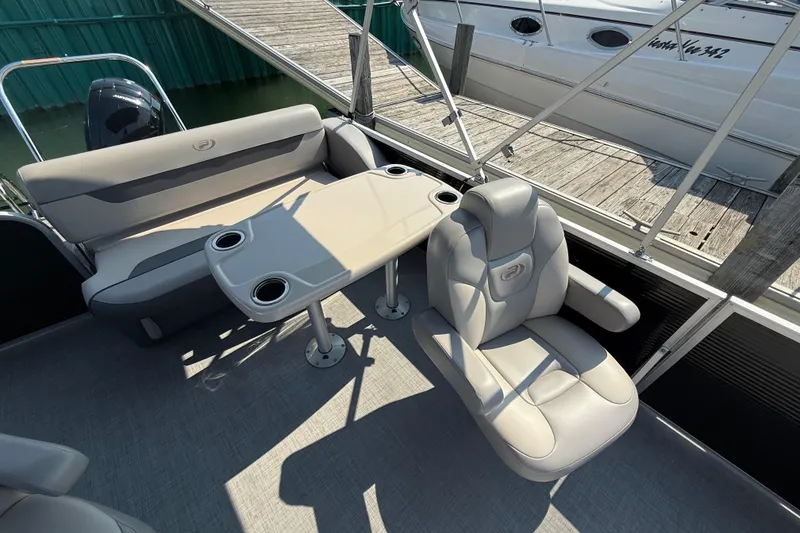 Slide: The Image of 2022 Princecraft Vectra 23 RL boat interior with seating and table, docked at marina. - 9