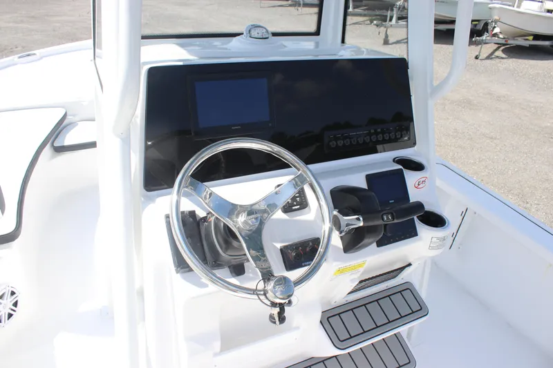 Slide: The Image of 2026 Tidewater 2210 Carolina Bay boat console with steering wheel and electronic controls. - 14