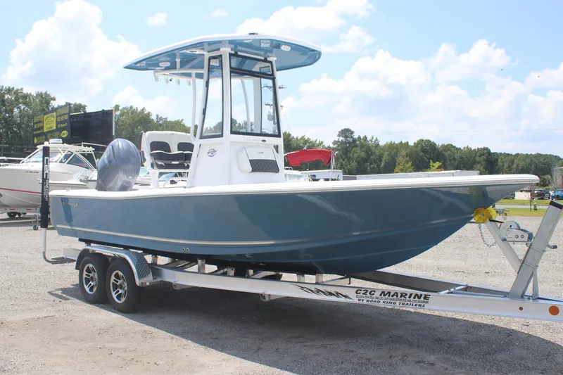 Slide: The Image of 2026 Tidewater 2210 Carolina Bay boat on trailer, parked outdoors under a blue sky. - 2