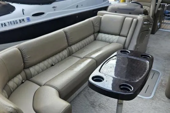 Slide: The Image of 2016 Bennington 2575 RCW boat interior with beige seating and a black table. - 6