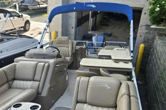 Slide: The Image of 2016 Bennington 2575 RCW pontoon boat with beige seating and blue canopy. - 8