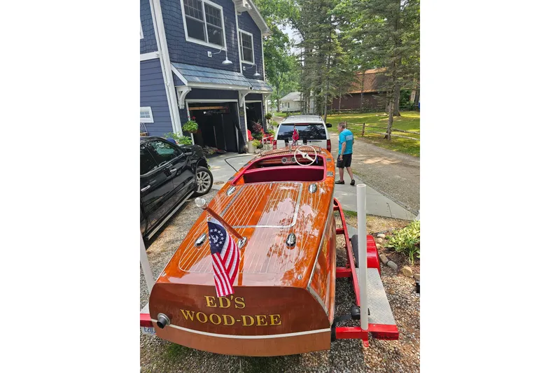 Slide: The Image of 1947 Chris Craft Barrel Back boat on trailer, labeled "ED'S WOOD-DEE," parked near a house. - 12