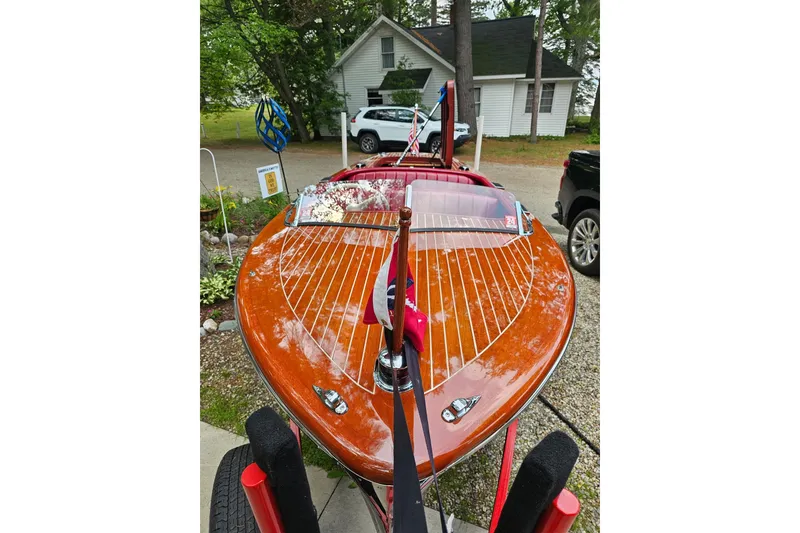 Slide: The Image of 1947 Chris Craft Barrel Back boat with polished wood finish, parked outdoors. - 13