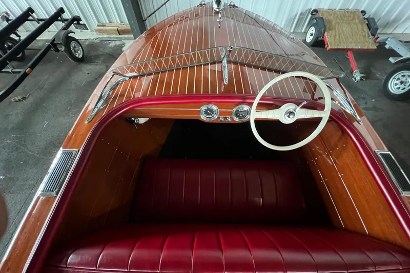 Slide: The Image of 1947 Chris Craft Barrel Back boat interior with wooden dashboard and red leather seating. - 4