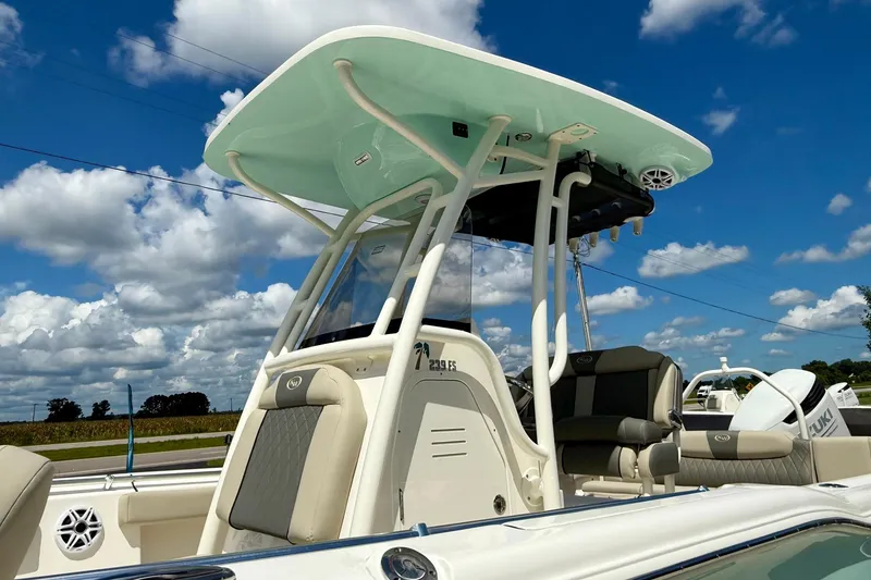 Slide: The Image of 2026 Key West 239 FS boat with T-top and seating, under a blue sky with clouds. - 11