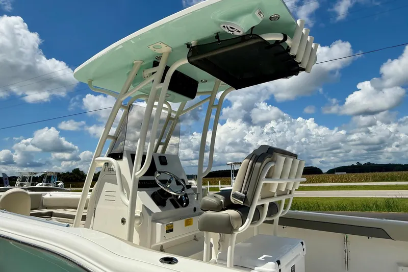 Slide: The Image of 2026 Key West 239 FS boat with T-top, parked near a marine building under a cloudy sky. - 12