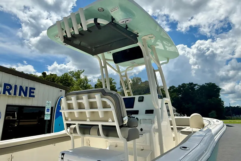 Slide: The Image of 2026 Key West 239 FS boat with cushioned seating, parked outdoors under a clear sky. - 13