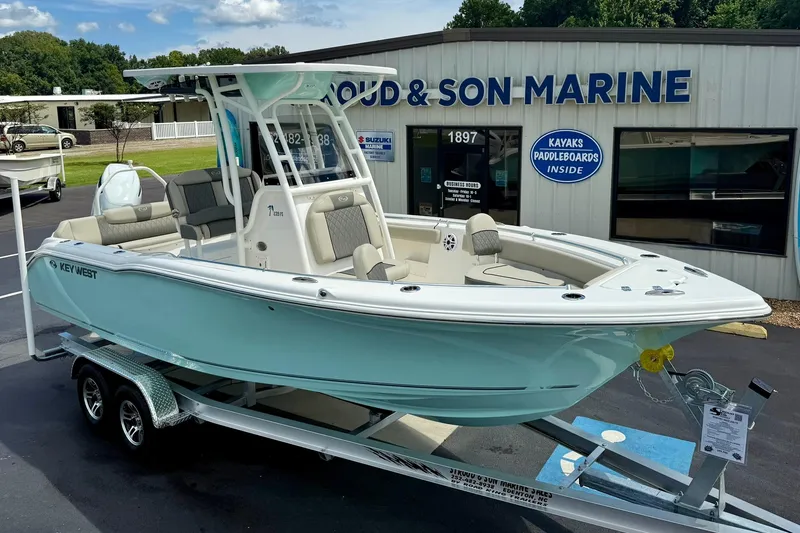 Slide: The Image of 2026 Key West 239 FS boat with T-top, displayed at a marine dealership. - 9