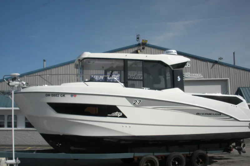 Slide: The Image of 2019 Beneteau Barracuda 9 boat on trailer, parked outside a marine facility. - 1