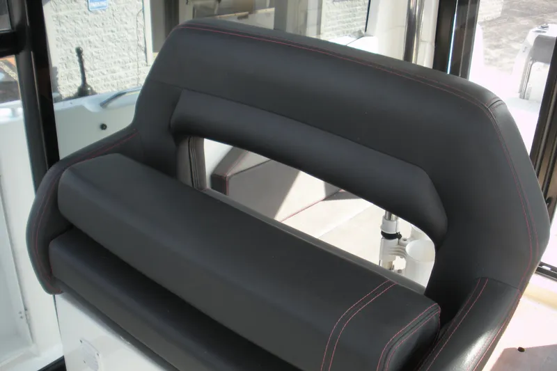 Slide: The Image of 2019 Beneteau Barracuda 9 interior seat with black upholstery and red stitching. - 15