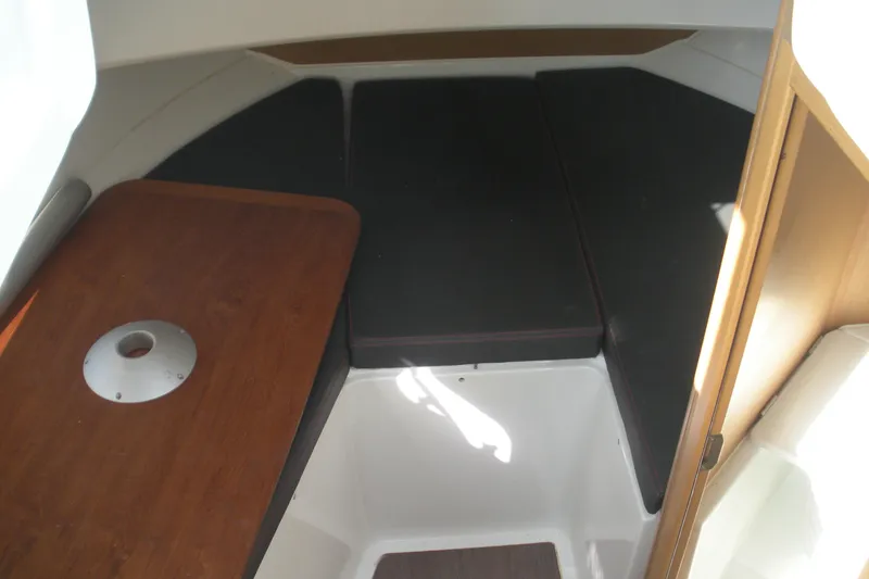 Slide: The Image of 2019 Beneteau Barracuda 9 cabin interior with wooden table and black cushions. - 7