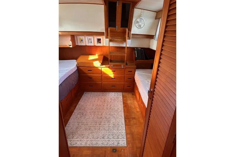 Slide: The Image of 1984 Grand Banks 42 Classic cabin interior with wooden furnishings and twin beds. - 11
