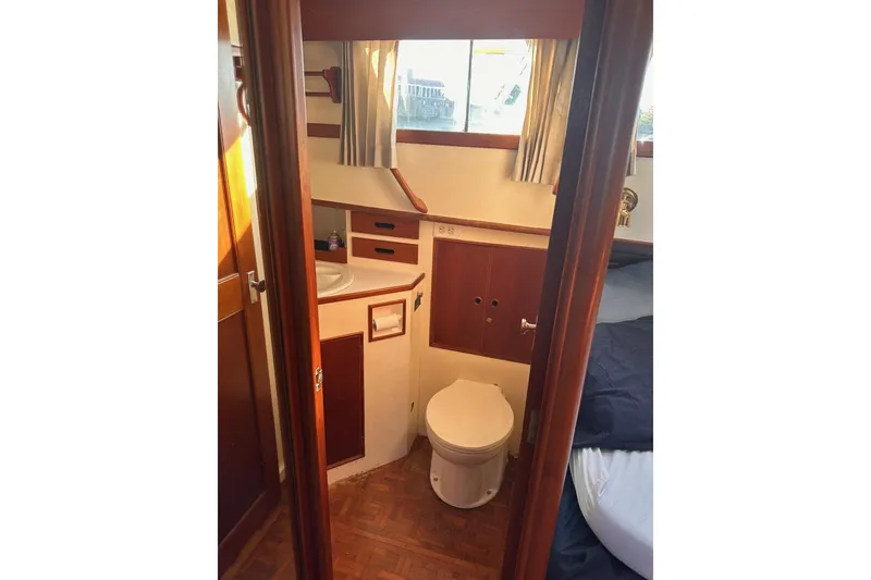 Slide: The Image of 1984 Grand Banks 42 Classic yacht bathroom with wooden cabinetry and window. - 13