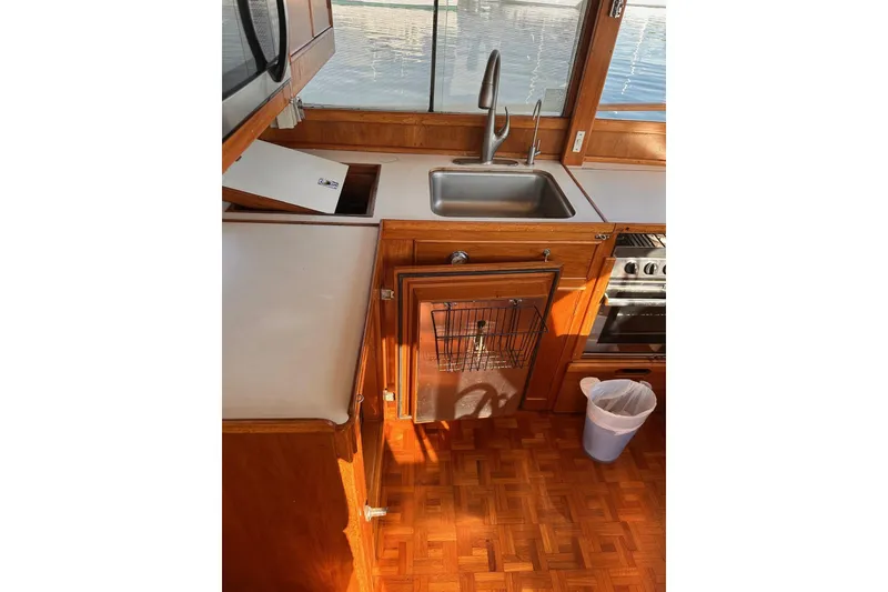 Slide: The Image of 1984 Grand Banks 42 Classic yacht kitchen with wooden cabinetry and stainless steel sink. - 7