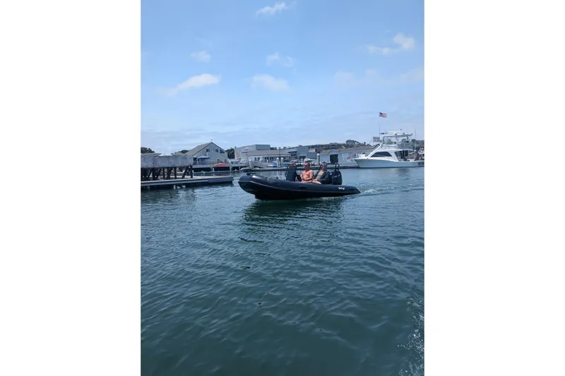 Slide: The Image of Tide Craft Custom Black & Tan Catalina 13 boat cruising in a marina, 2026 model. - 6