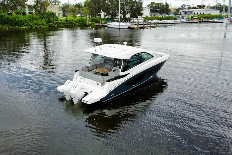 Slide: The Image of 2022 Beneteau Gran Turismo 32 cruising on a calm river near a marina. - 1