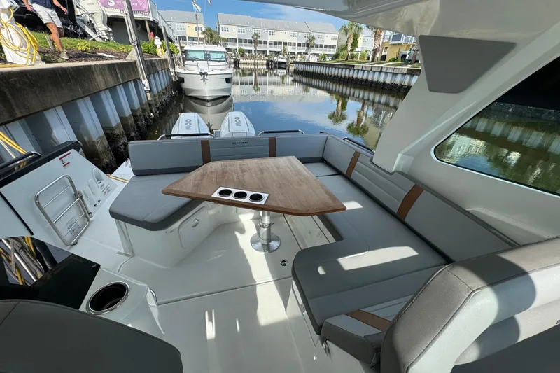 Slide: The Image of 2022 Beneteau Gran Turismo 32 yacht interior with seating and table, docked in marina. - 12