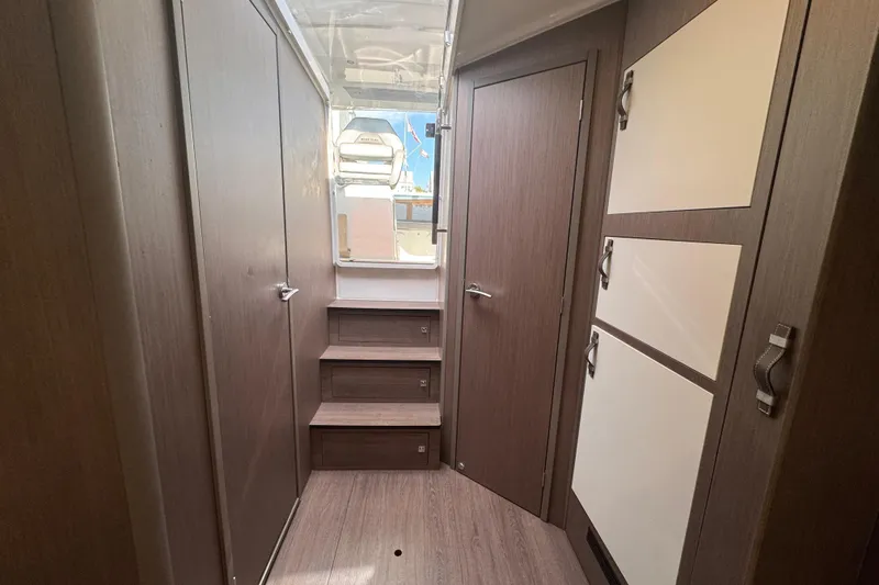Slide: The Image of Interior of 2022 Beneteau Gran Turismo 32 yacht, featuring modern wood paneling and storage. - 18