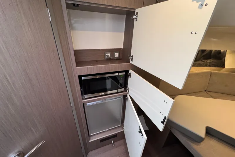 Slide: The Image of Interior of 2022 Beneteau Gran Turismo 32 yacht with open cabinets and microwave. - 20