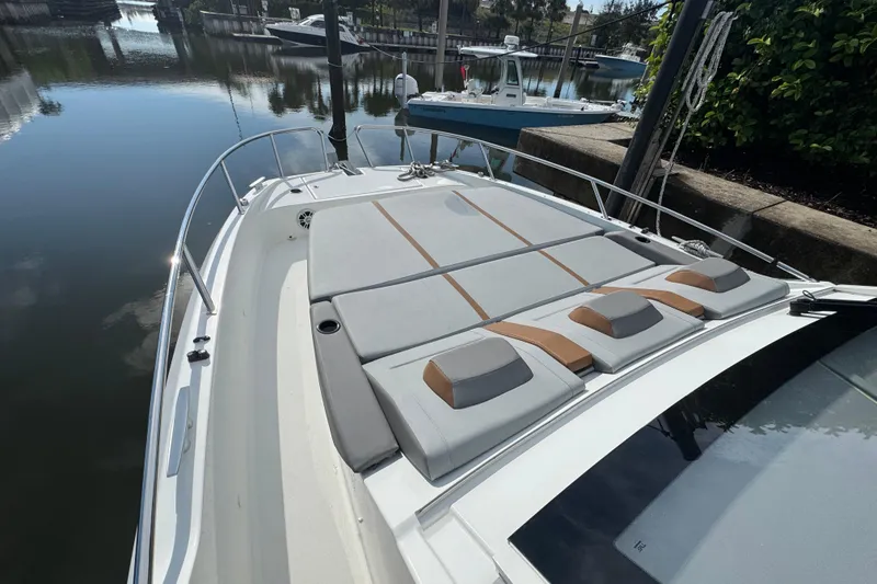 Slide: The Image of 2022 Beneteau Gran Turismo 32 yacht with spacious sunbathing deck in a serene marina setting. - 23