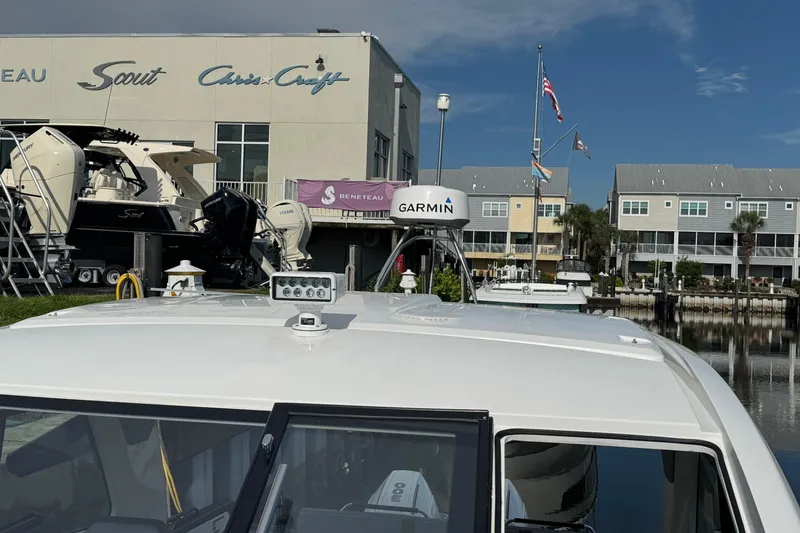 Slide: The Image of 2022 Beneteau Gran Turismo 32 at marina with Garmin equipment, Scout and Chris-Craft boats visible. - 26