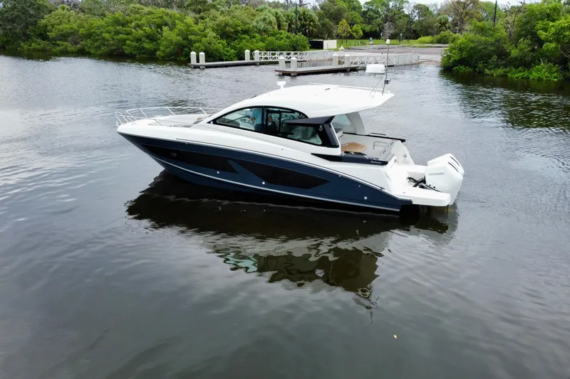 Slide: The Image of 2022 Beneteau Gran Turismo 32 yacht on calm water, surrounded by lush greenery. - 4