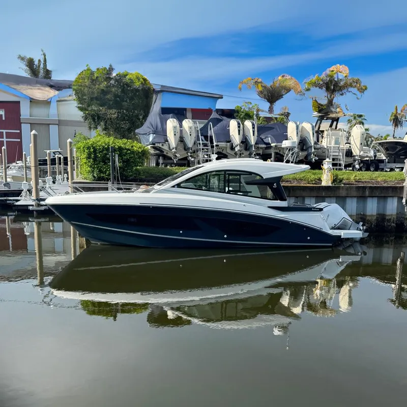 Slide: The Image of 2022 Beneteau Gran Turismo 32 yacht docked in a marina, reflecting on calm water. - 5