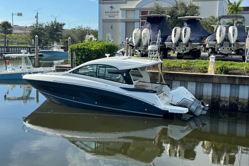 Slide: The Image of 2022 Beneteau Gran Turismo 32 yacht docked at marina, reflecting on calm water. - 6