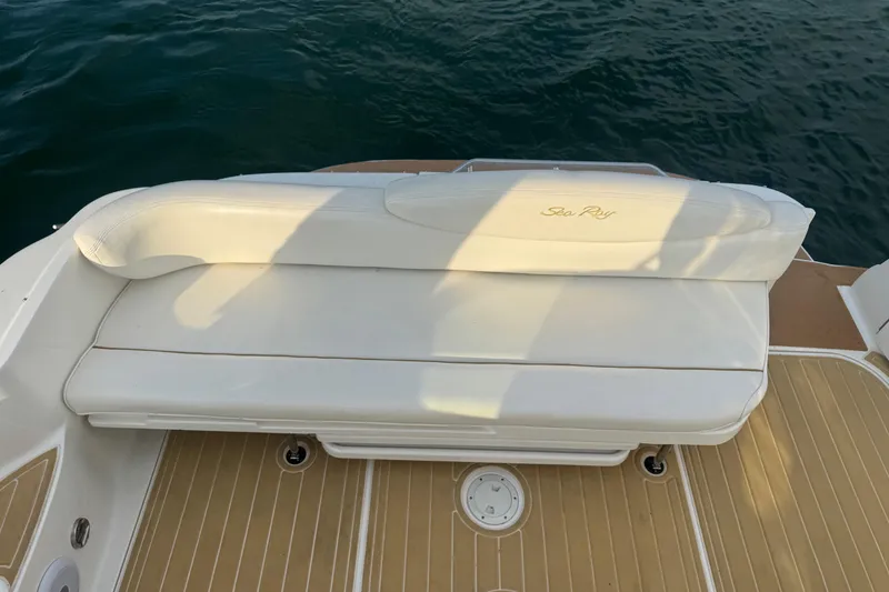 Slide: The Image of White leather seating on 2000 Sea Ray 340 Sundancer boat, with teak deck and water backdrop. - 13