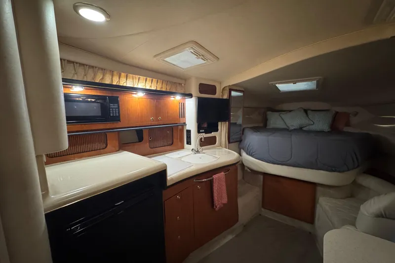 Slide: The Image of Interior of 2000 Sea Ray 340 Sundancer with kitchenette and cozy sleeping area. - 19