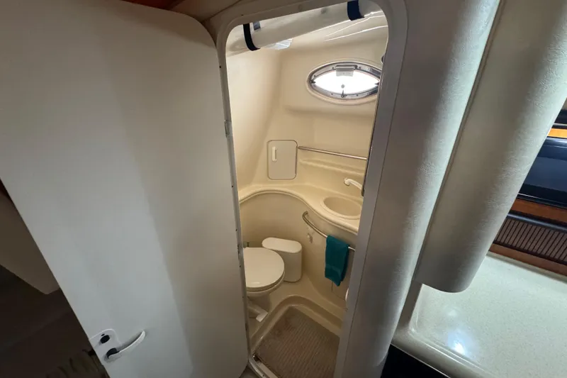 Slide: The Image of Bathroom interior of 2000 Sea Ray 340 Sundancer yacht, featuring compact design and porthole window. - 23