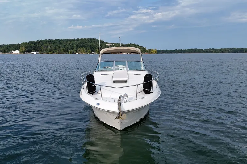 Slide: The Image of 2000 Sea Ray 340 Sundancer boat on a calm lake with forested shoreline. - 4