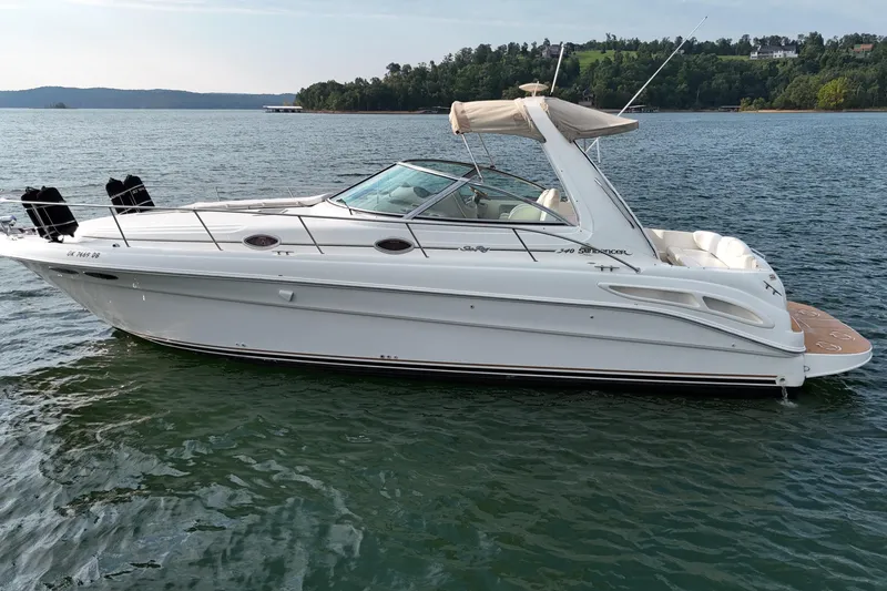Slide: The Image of 2000 Sea Ray 340 Sundancer boat on a calm lake with scenic background. - 6