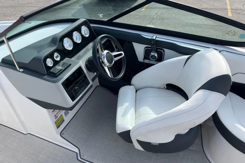 Slide: The Image of 2021 Regal 2300 Bowrider cockpit with steering wheel and gauges, featuring a comfortable captain's chair. - 11