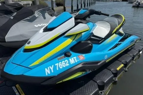 Slide: The Image of 2023 Yamaha WaveRunner FX Cruiser HO in blue and yellow, docked by the water. - 0