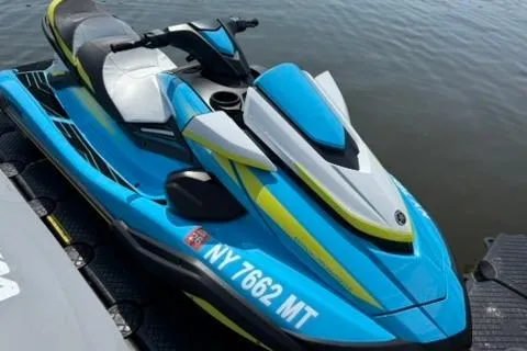 Slide: The Image of 2023 Yamaha WaveRunner FX Cruiser HO in blue and yellow on water. - 2