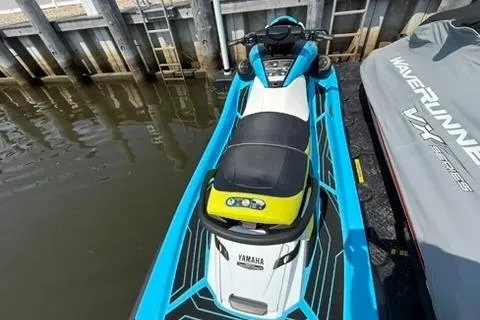 Slide: The Image of 2023 Yamaha WaveRunner FX Cruiser HO in vibrant blue and yellow, docked by the water. - 4