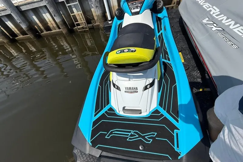 Slide: The Image of 2023 Yamaha WaveRunner FX Cruiser HO in vibrant blue docked by the water. - 5