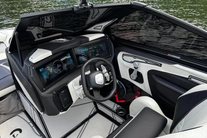 Slide: The Image of 2024 Centurion Fi23 boat cockpit with modern dashboard and steering wheel, overlooking water. - 10