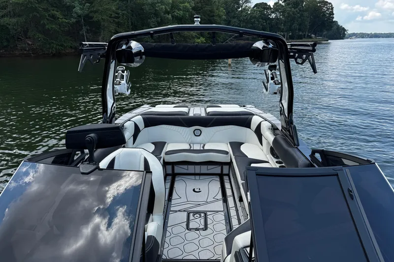 Slide: The Image of 2024 Centurion Fi23 boat interior with sleek seating and modern design on a calm lake. - 12