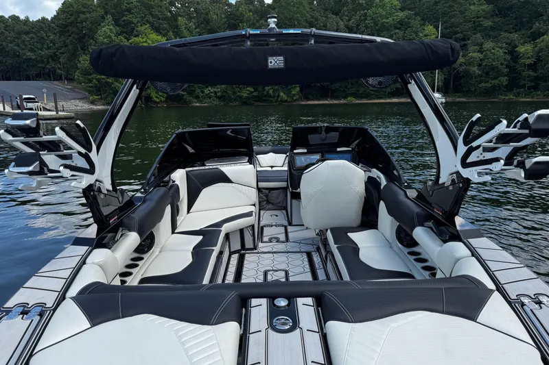 Slide: The Image of 2024 Centurion Fi23 boat interior with luxurious seating on a serene lake. - 9