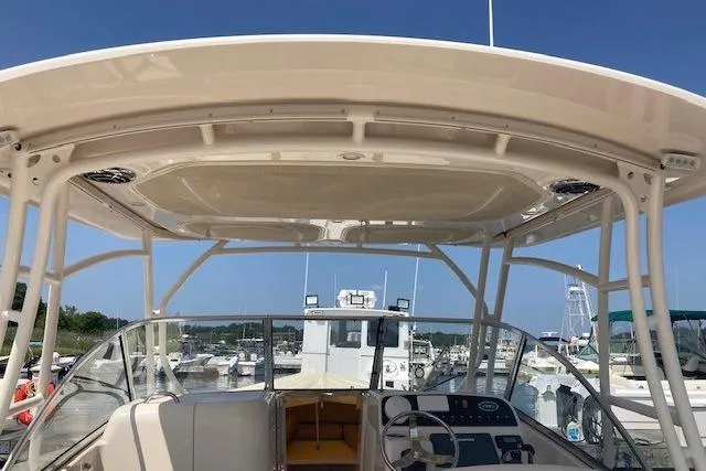Slide: The Image of 2014 Grady-White Freedom 285 boat interior with helm and seating, docked at marina. - 12