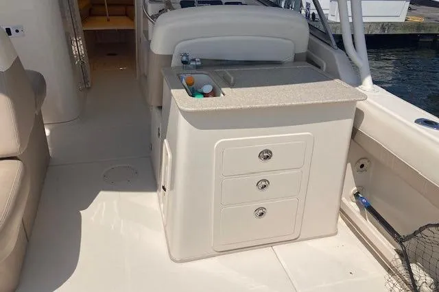 Slide: The Image of 2014 Grady-White Freedom 285 boat interior with storage drawers and sink. - 13