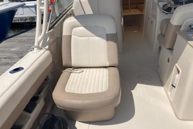 Slide: The Image of 2014 Grady-White Freedom 285 boat interior with beige seating and helm area. - 14