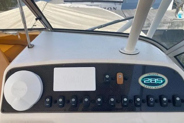 Slide: The Image of Control panel of 2014 Grady-White Freedom 285 boat with switches and logo. - 17
