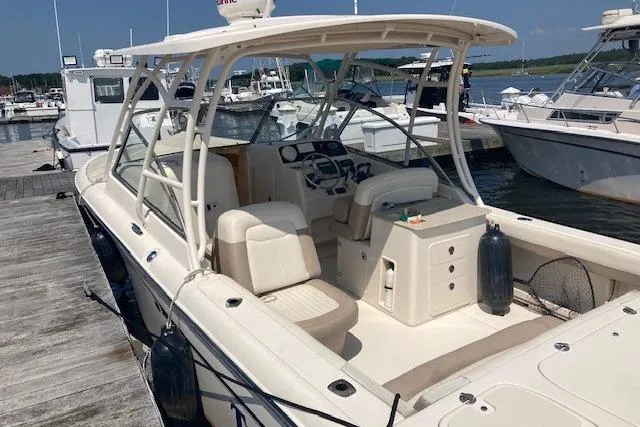 Slide: The Image of 2014 Grady-White Freedom 285 boat docked, featuring spacious seating and modern controls. - 4