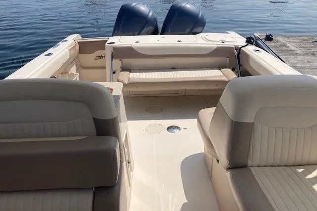 Slide: The Image of 2014 Grady-White Freedom 285 boat interior with seating and twin engines on water. - 5