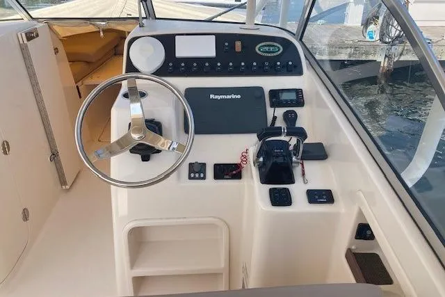 Slide: The Image of 2014 Grady-White Freedom 285 boat dashboard with steering wheel and navigation controls. - 8