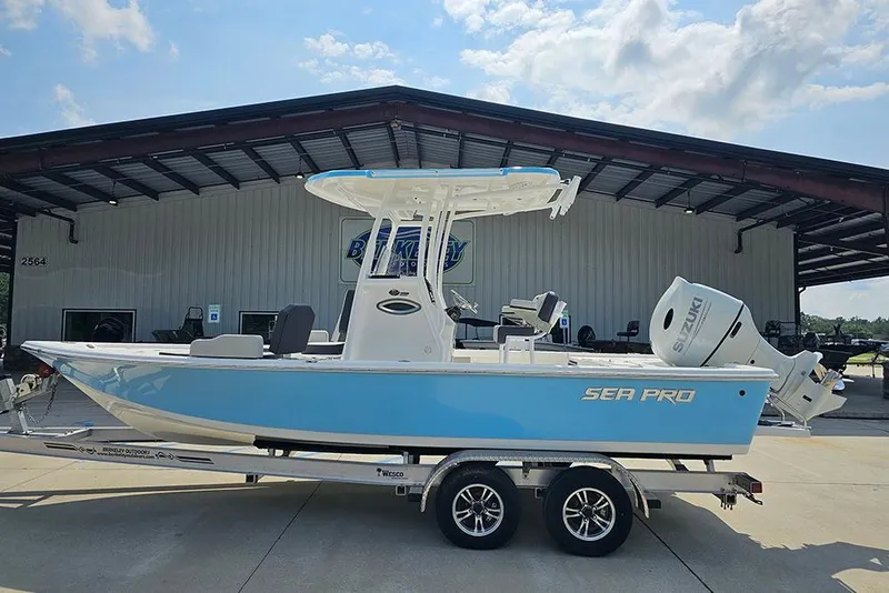 The Image of 2026 Sea Pro 230 Bay boat on trailer, blue hull, parked outdoors. - 0