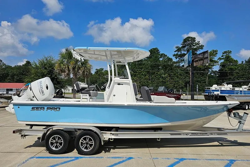 Slide: The Image of 2026 Sea Pro 230 Bay boat on trailer, blue and white design, parked outdoors. - 5